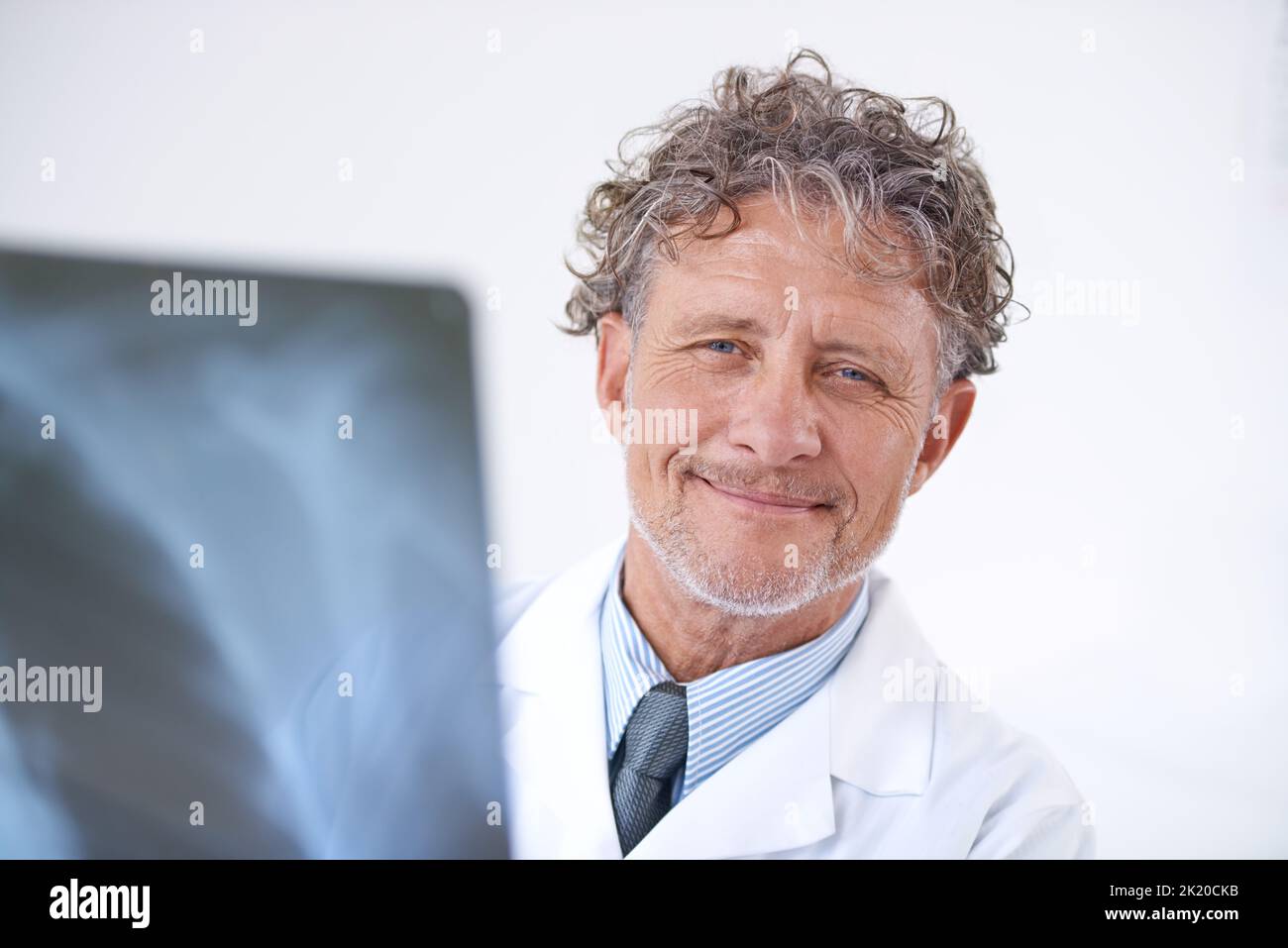Tutto sembra buono per me. Ritratto di un medico sorridente maturo che tiene una radiografia. Foto Stock