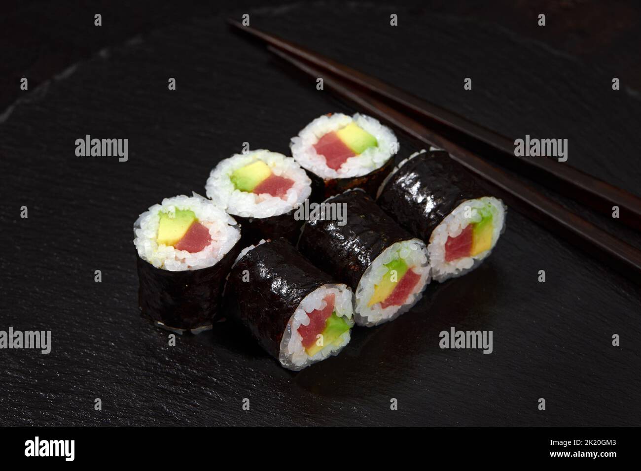 Set di panini di sushi di tonno e avokado su sfondo nero Foto Stock