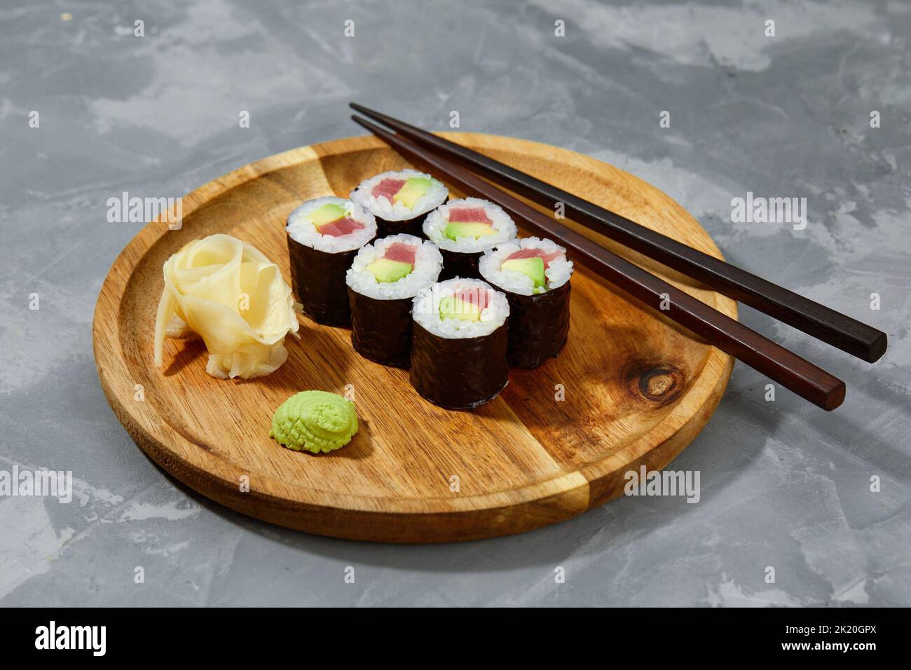 Set di panini di sushi di tonno e avokado su tavola di legno e sfondo di pietra grigia Foto Stock