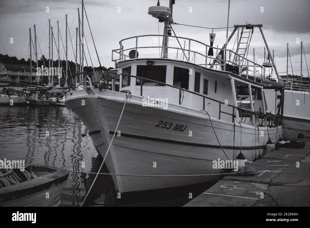 Un primo piano di una grande barca fisher in scala di grigi che si trova nel porto della Croazia Foto Stock