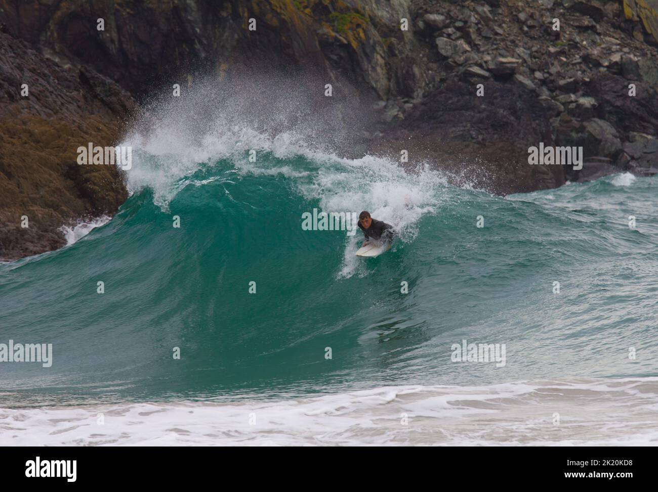 Un surfista nel surf a Kynance Cove sulla penisola di Lizard, Cornovaglia, Inghilterra Foto Stock