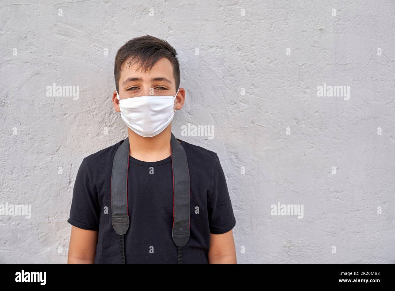 Un ragazzino carino con occhi verdi che indossa una maschera . Foto Stock