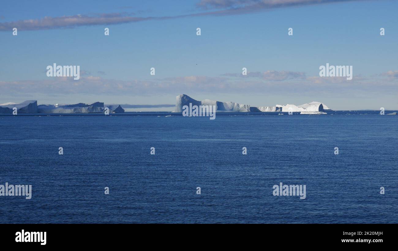 Vista panoramica degli iceberg sul mare calmo durante la crociera in Groenlandia Foto Stock
