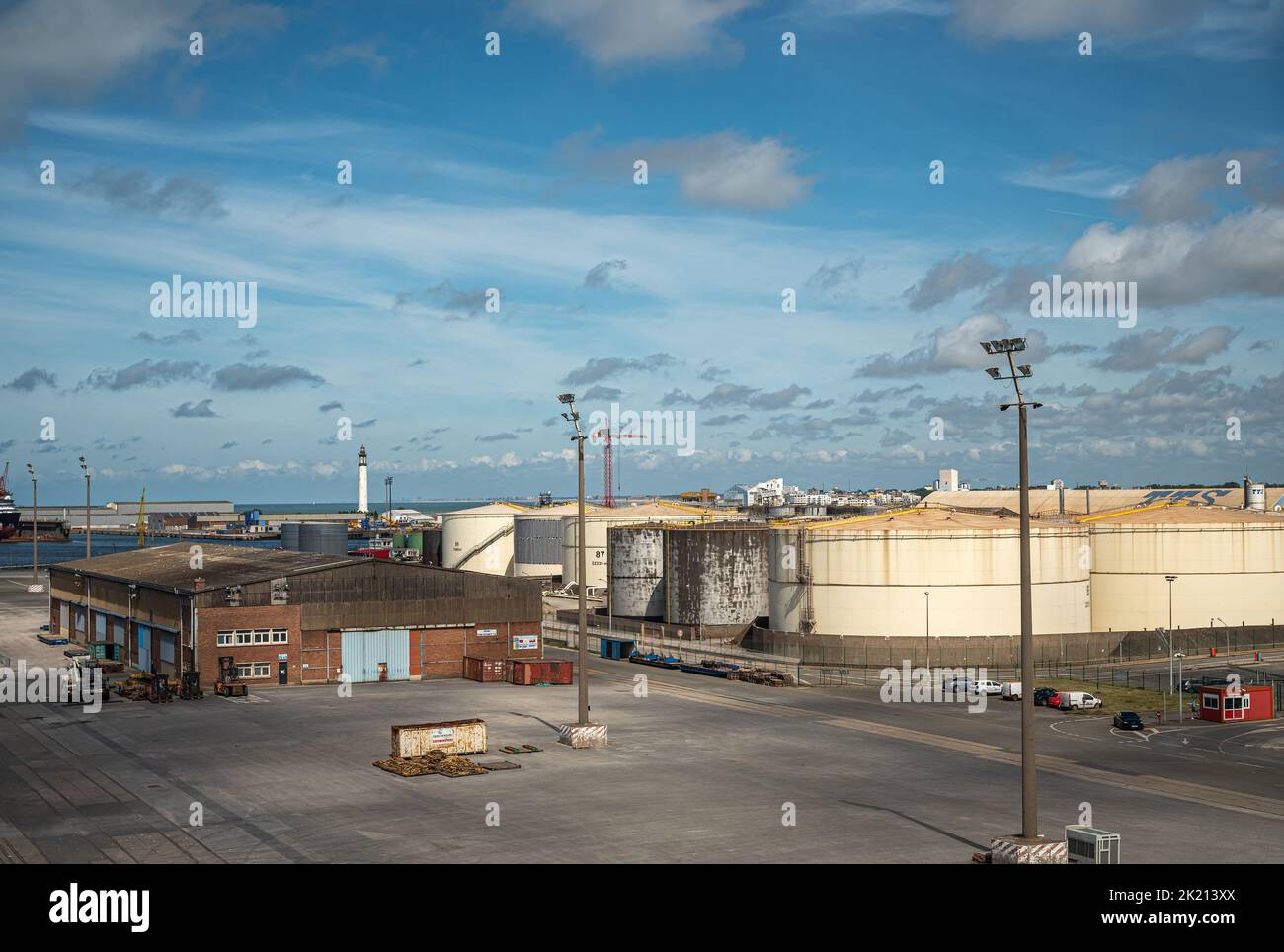 Europa, Francia, Dunkerque - 9 luglio 2022: Scenario del porto. BARRA SNM Terminal e uffici di fronte ai grandi serbatoi cilindrici di petrolio sotto Foto Stock