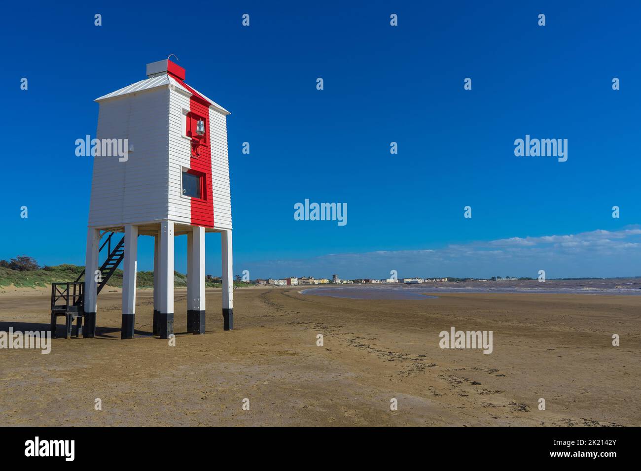 In piedi su palafitte, il faro di legno sulla spiaggia vicino Burnham on Sea. Il faro è dipinto di bianco con un'unica striscia rossa sul fronte Foto Stock