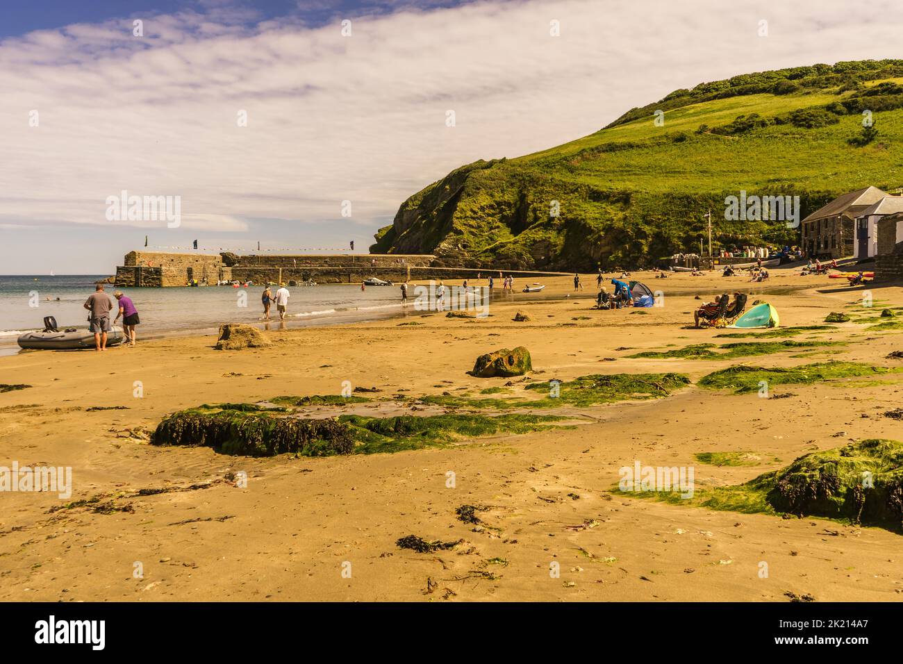 Estate giorno sulla spiaggia a Gorran Haven in Cornovaglia, la gente si è seduto sulla spiaggia godendo la loro vacanza. Gorran Haven è un popolare villaggio turistico. Foto Stock