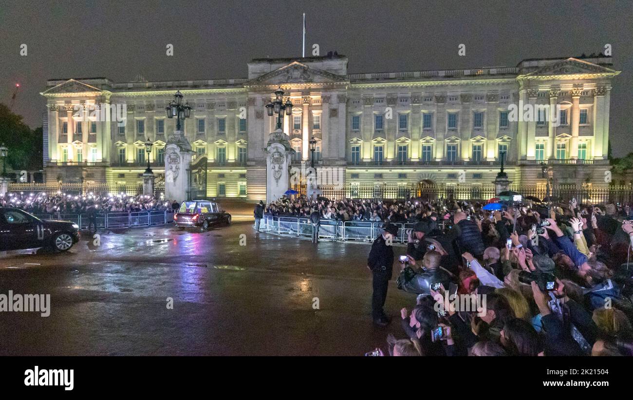 Le folle aspettano alle porte di Buckingham Palace per arrivare sotto la pioggia. La nazione continua a piangere la morte della Regina Elisabetta II Immagine ripresa Foto Stock