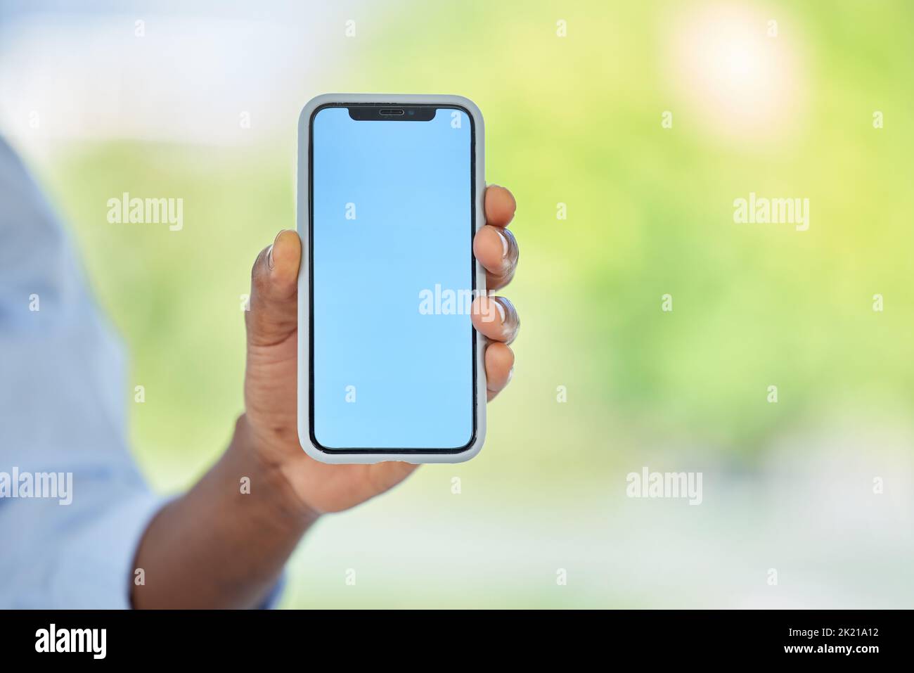 Telefono, schermo blu e mockup spazio per il marketing, il sito web aziendale e la pubblicità marchio. Zoom su lavoratore, mano o uomo d'affari con il logo di avvio Foto Stock