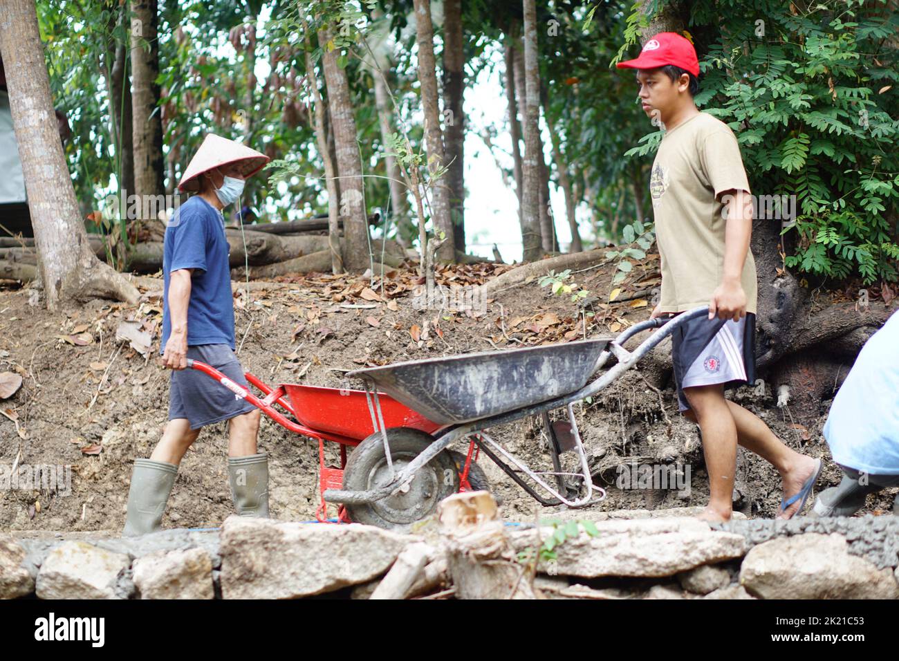 Un primo piano del popolo di Bangunjiwo Bantul Village costruendo le strade insieme Foto Stock