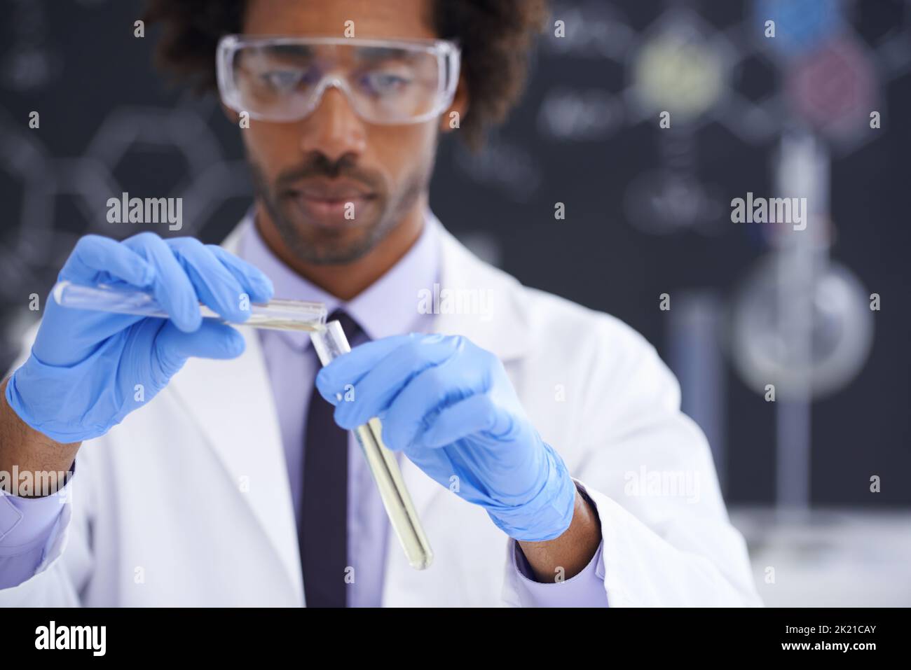 Mescolando le cose in su. Uno scienziato maschio che conduce un esperimento nel suo laboratorio. Foto Stock
