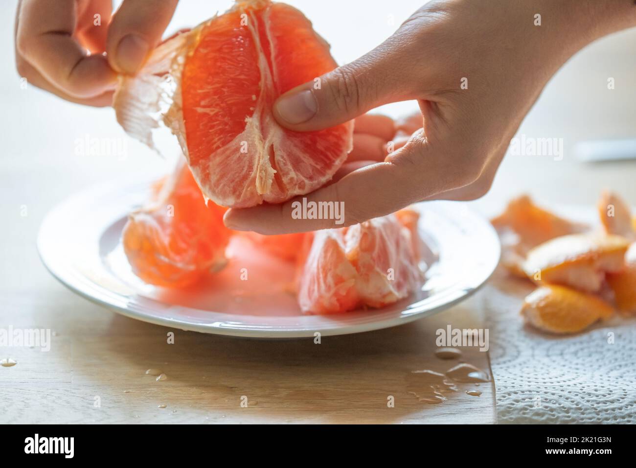 Pompelmo.frutta di agrumi. Peeling delle mani a pompelmo.pompelmo fresco e succoso.gocce di succo di pompelmo.frutta per colazione. Foto Stock