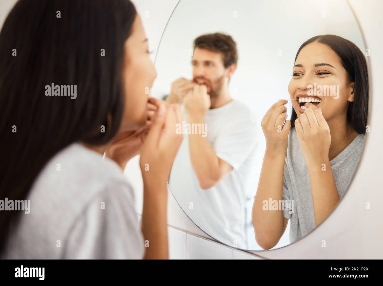 Specchio, filo interdentale e denti sanitari coppia pulizia bocca per gengive sane, sorriso e respiro fresco. Uomo e donna in bagno che galleggiavano la mattina Foto Stock