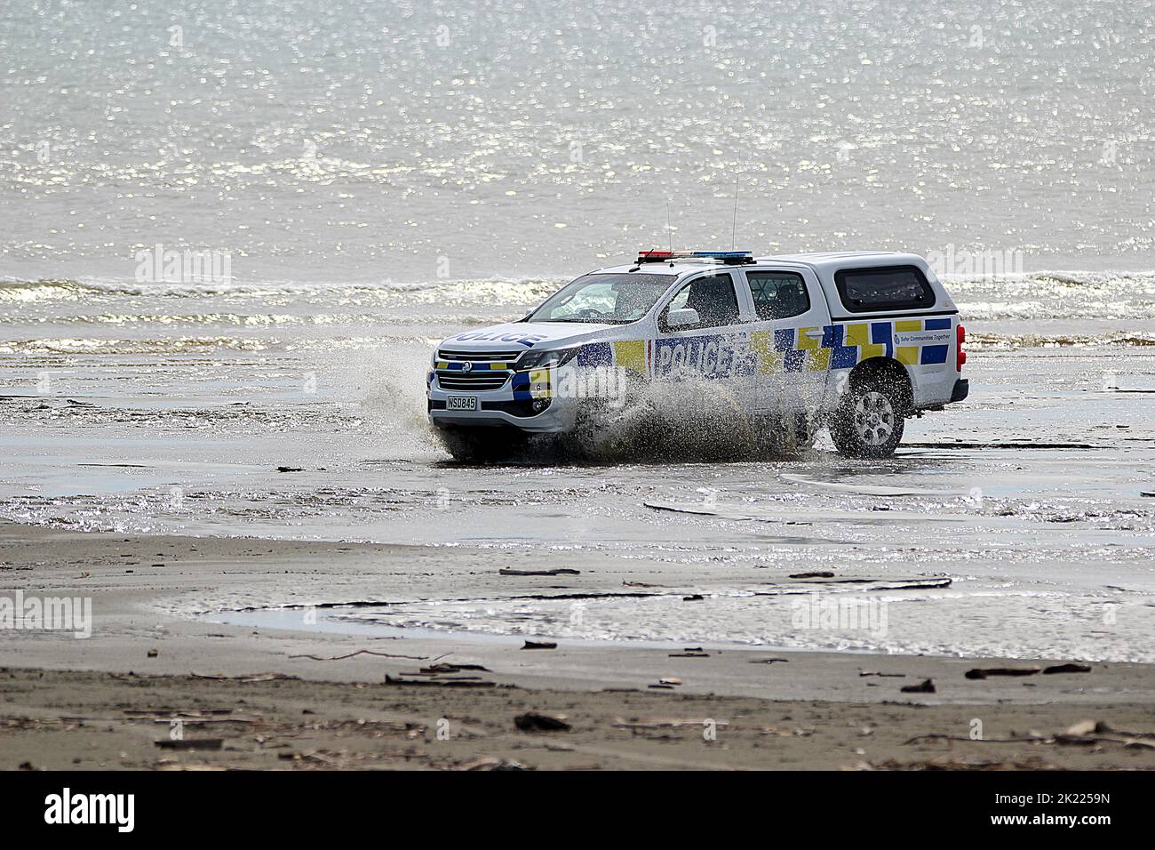 Veicolo della polizia neozelandese che guida in spiaggia Foto Stock