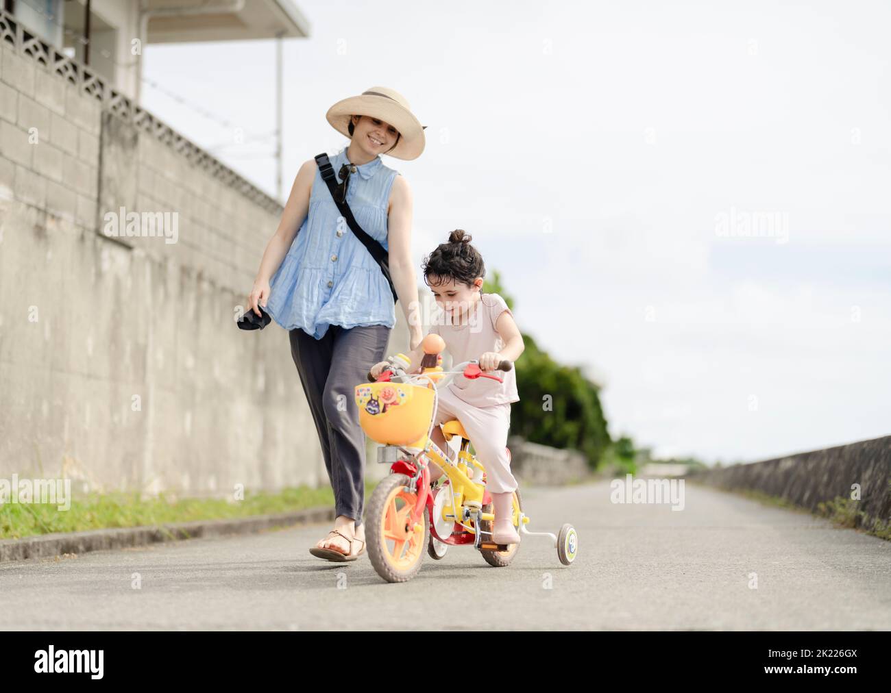Madre e figlia - imparare a guidare una bicicletta Foto Stock