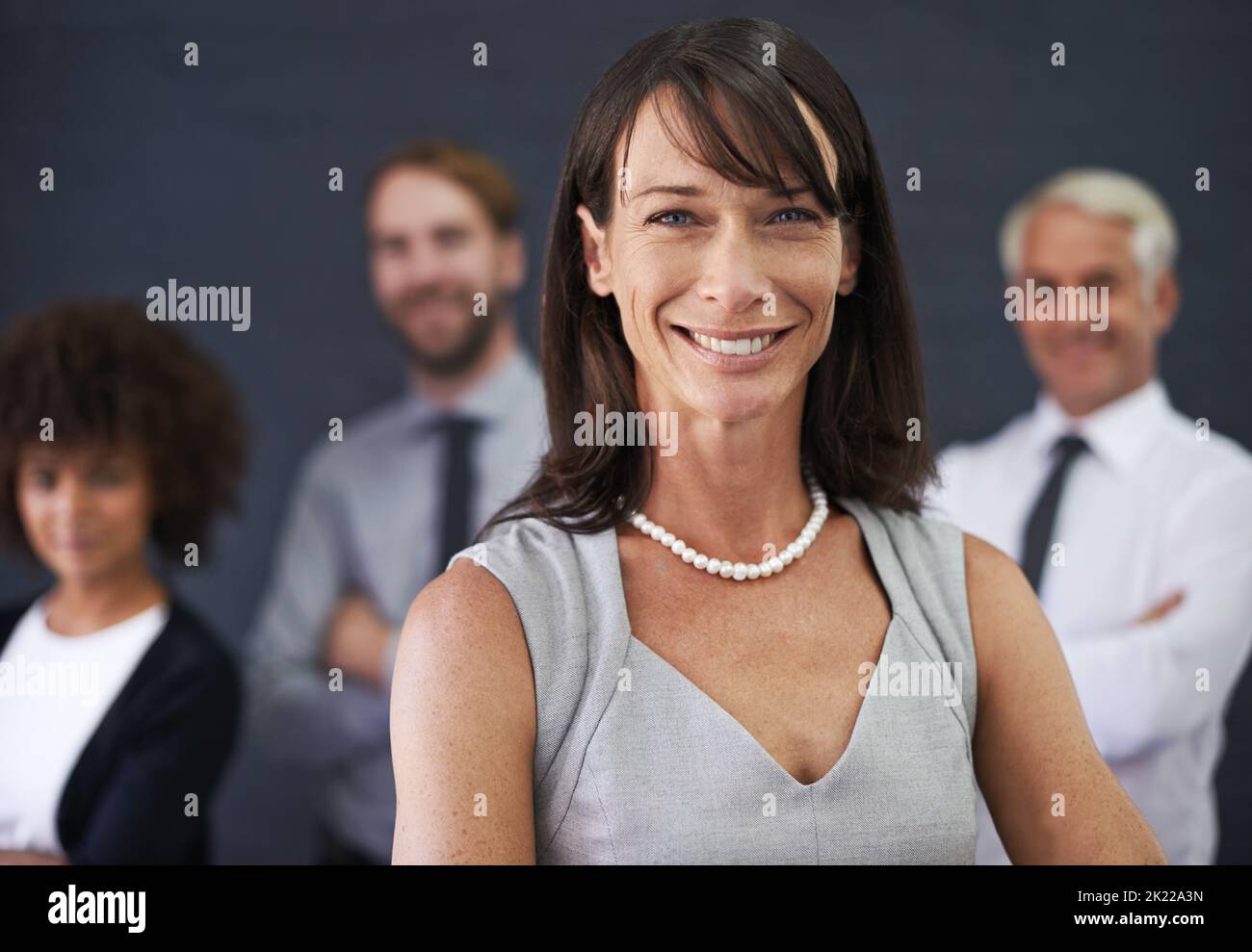 Il lavoro di squadra fa il lavoro di sogno. Una donna professionista che si trova davanti a un gruppo di colleghi. Foto Stock
