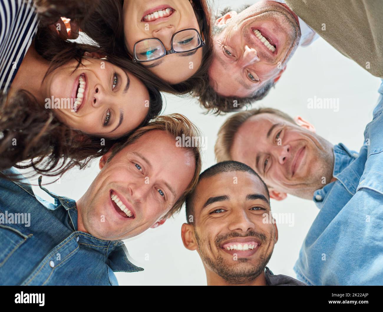 Comunità di persone simili. Inquadratura ad angolo basso di sei persone che mettono la testa in cerchio. Foto Stock