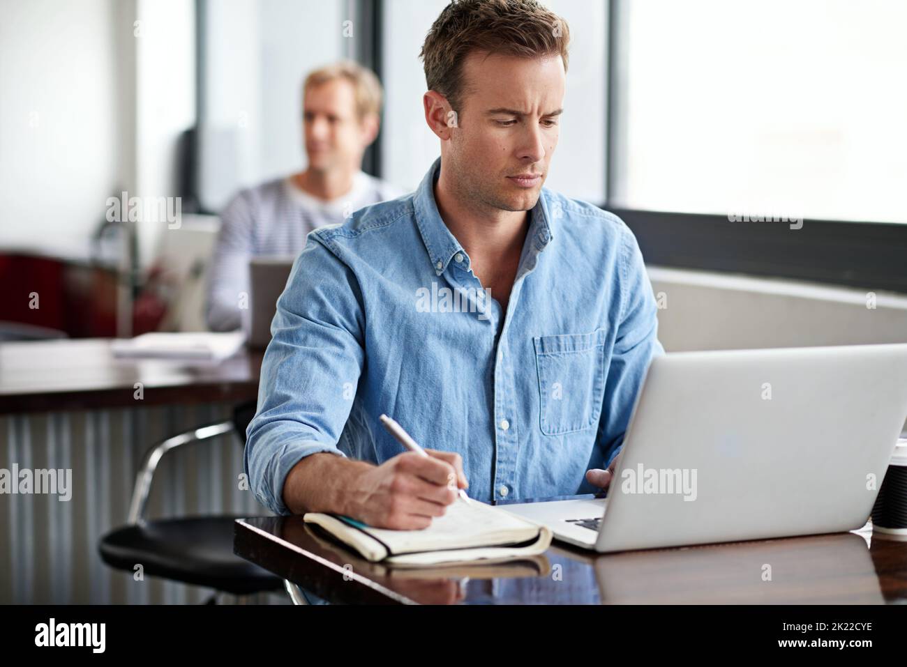 Siate proattivi nel vostro successo. Un uomo che lavora su un notebook in ufficio. Foto Stock