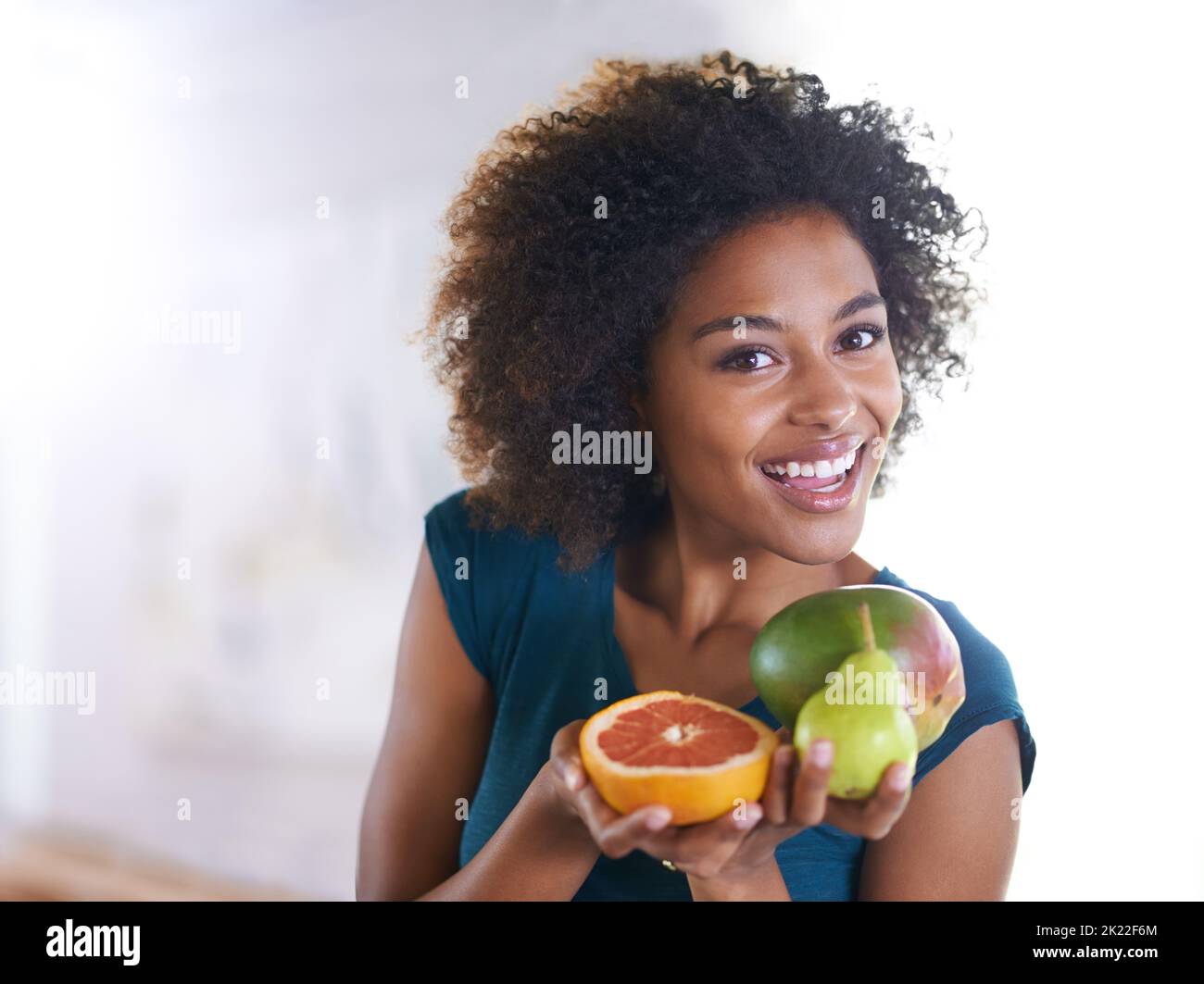 La dose giornaliera di vitamine. Vista dall'alto ripresa di una bella giovane donna che offre una selezione di prodotti freschi. Foto Stock