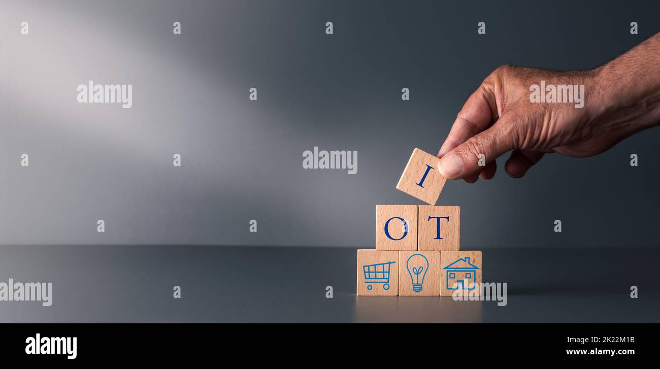 internet delle cose, mano posando blocchi di legno, concetto di i o T, su sfondo grigio blu. Foto Stock