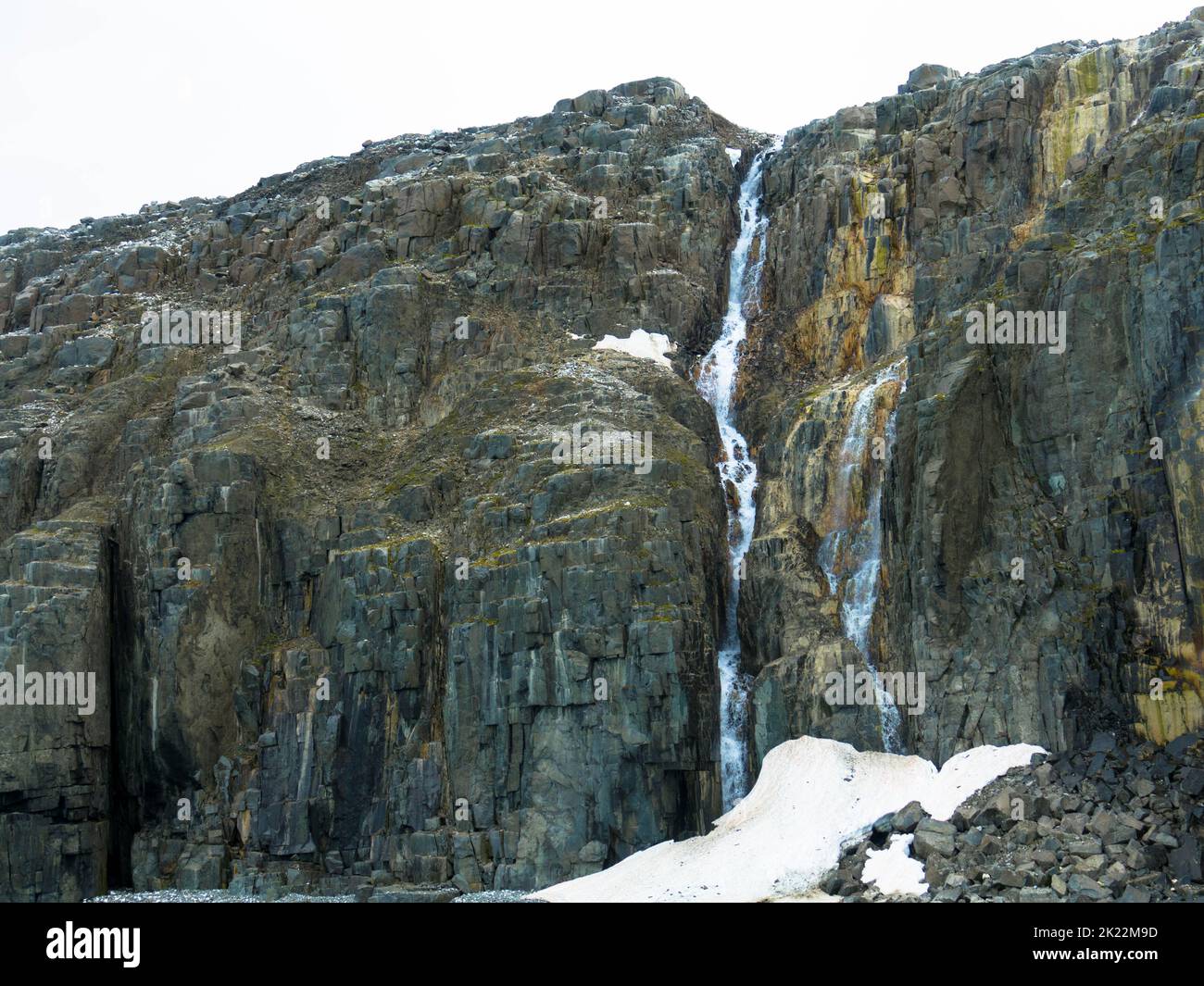 Vista spettacolare di una cascata presso un ghiacciaio. La scogliera degli uccelli di Alkefjellet è la scogliera più famosa dell'arcipelago di Spitsbergen. Hinlopen Fjord, Svalbard. Foto Stock