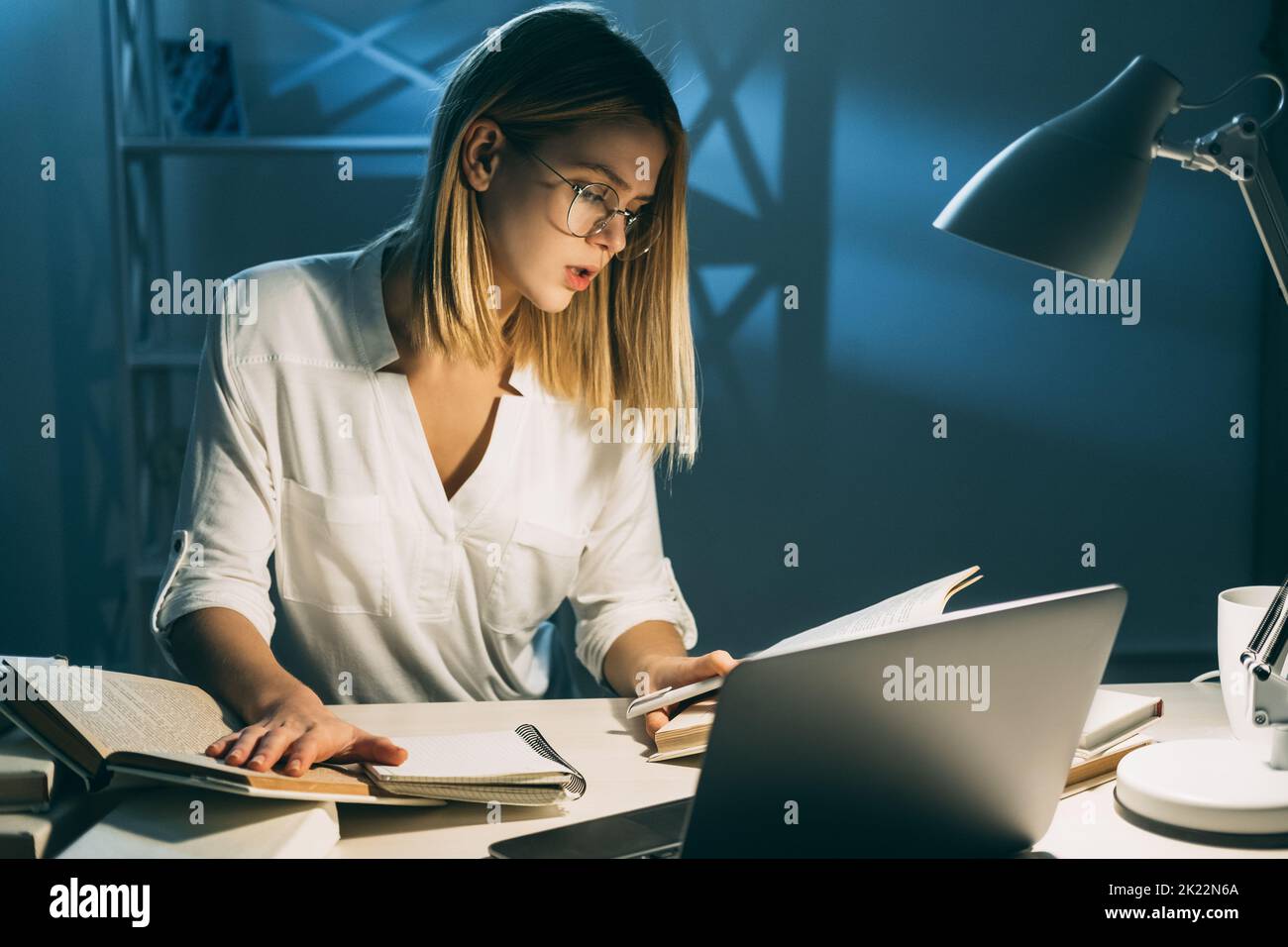Pandemic bloccare l'istruzione. Apprendimento a distanza. Gli studenti leggono libri facendo i compiti preparandosi agli esami seduti alla scrivania Foto Stock