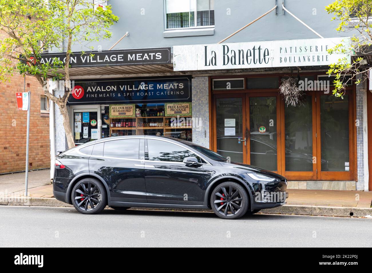 2020 veicolo elettrico Tesla Model X EV parcheggiato all'esterno di macellaio e pasticcerie a Avalon Beach, Sydney, NSW, Australia Foto Stock
