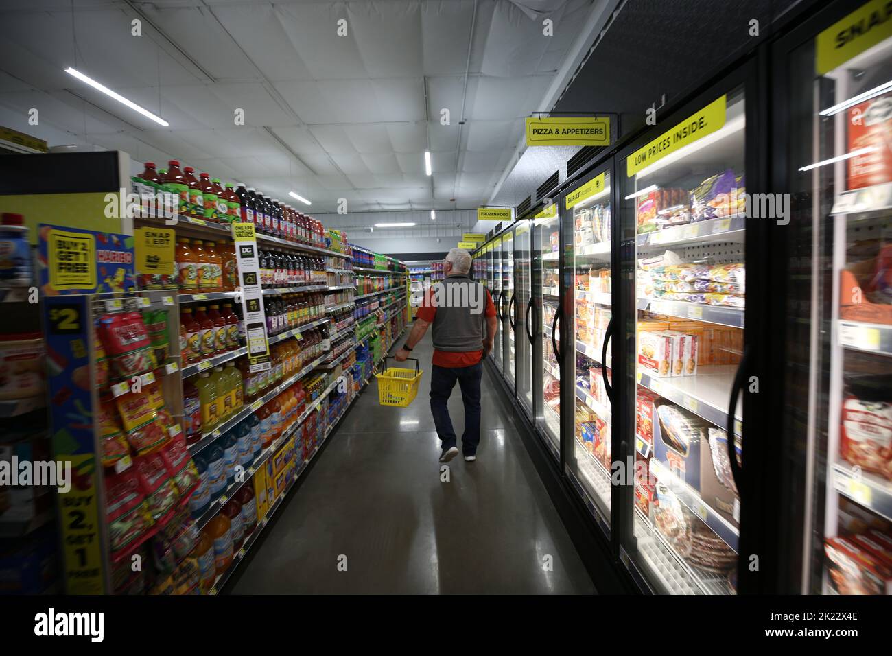 Un vecchio cliente negozi nelle navate soda di un Dollar General store Foto Stock