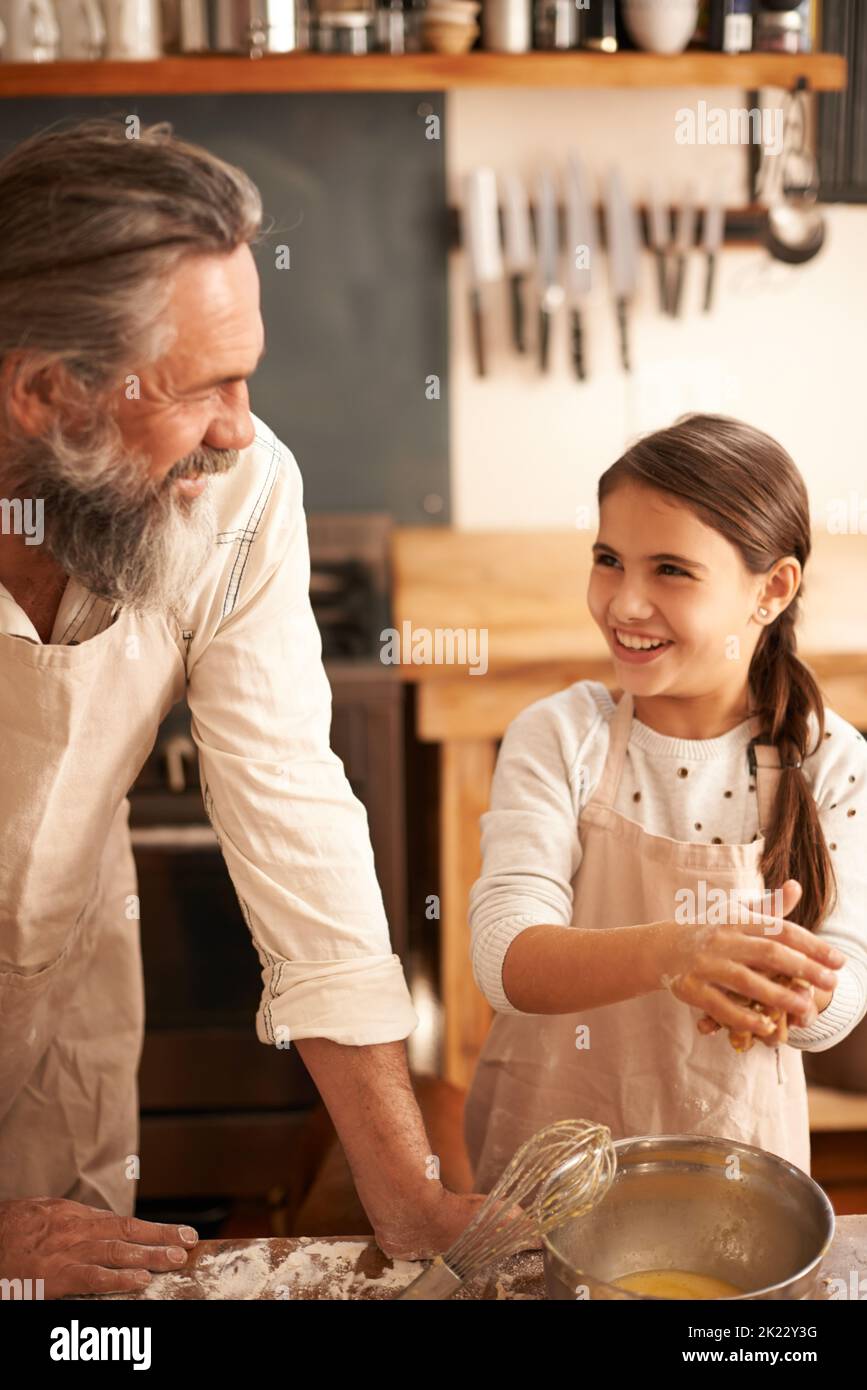 Nonno, dove hai imparato a cuocere. Una ragazza che si lega con suo nonno mentre cuocevano. Foto Stock