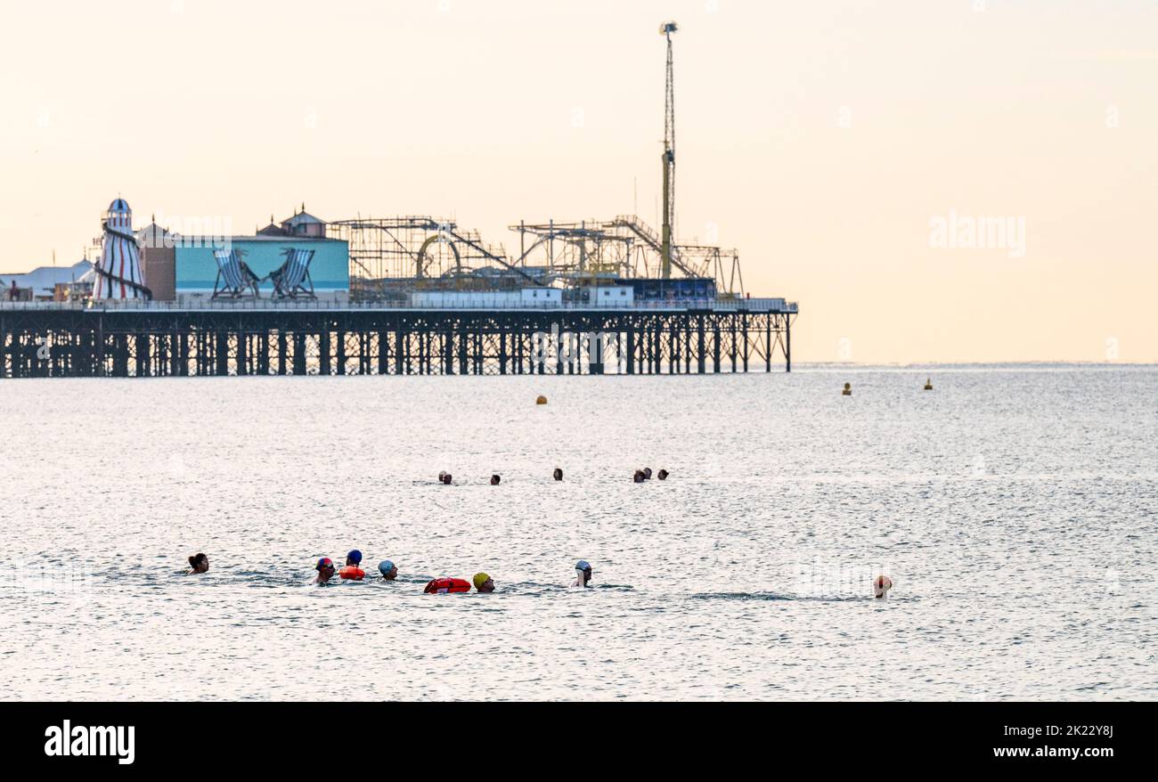 Brighton UK 22nd settembre 2022 - i nuotatori di mare di mattina presto a Brighton godono il sole luminoso ma il tempo fresco come le condizioni più difficili sono previste per i prossimi giorni . . : Credit Simon Dack / Alamy Live News Foto Stock