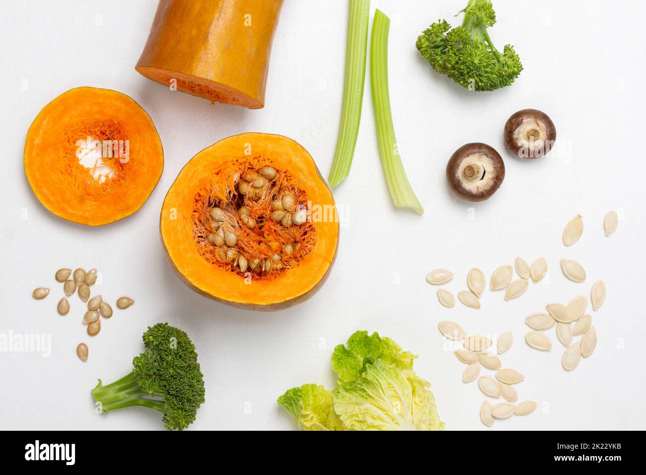 Gambi di sedano, broccoli e cavolo cinese, funghi, semi di zucca e zucca tritata. Giacitura piatta. Sfondo bianco. Foto Stock