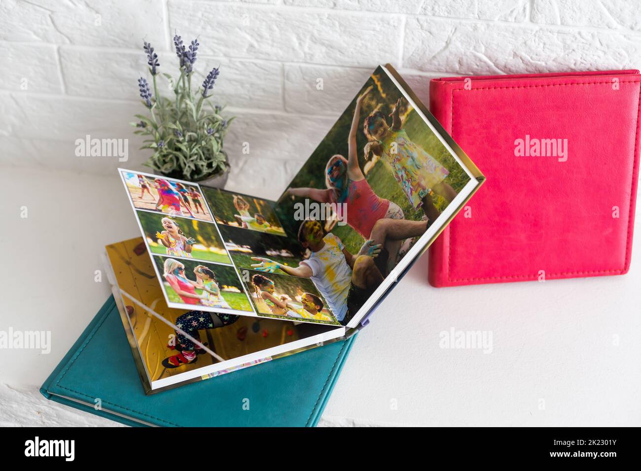 libro fotografico con copertina in pelle. Elegante album fotografico. Famiglia photoalbum sul tavolo bianco. Bellissimo blocco note o fotobook con elegante apertura Foto Stock