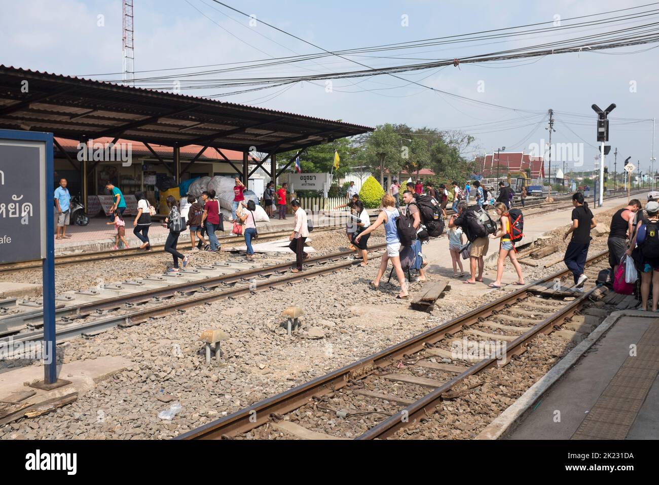 Passeggeri che attraversano i binari dopo l'arrivo alla stazione ferroviaria di Ayutthaya Thailandia Foto Stock