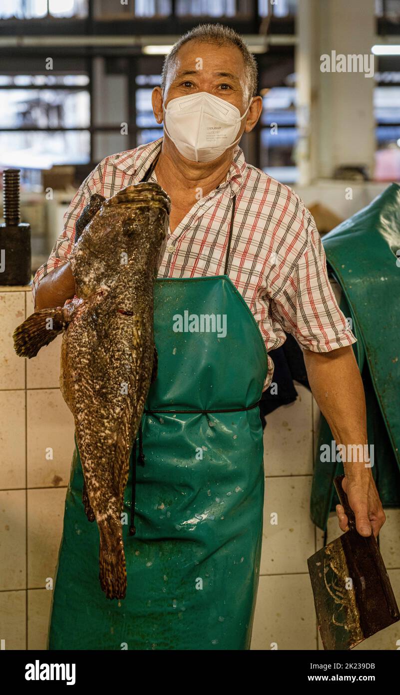Malesia, 10 luglio 2022 - l'uomo che tiene il pesce enorme sta vendendo nel fornitore del mercato. Foto Stock
