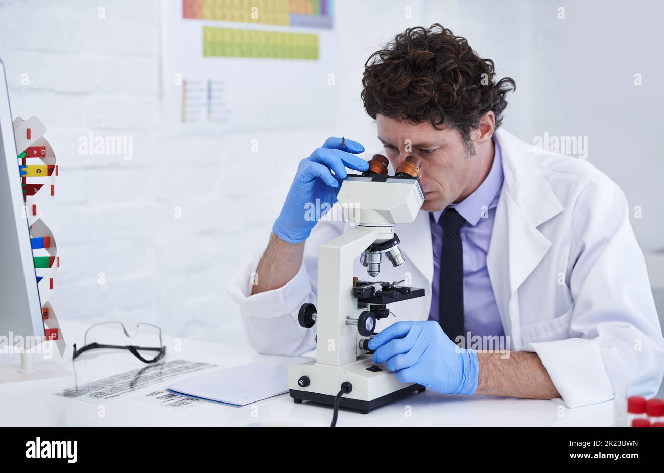 Theres nessun particolare a piccolo... Uno scienziato che osserva qualcosa con un microcope. Foto Stock