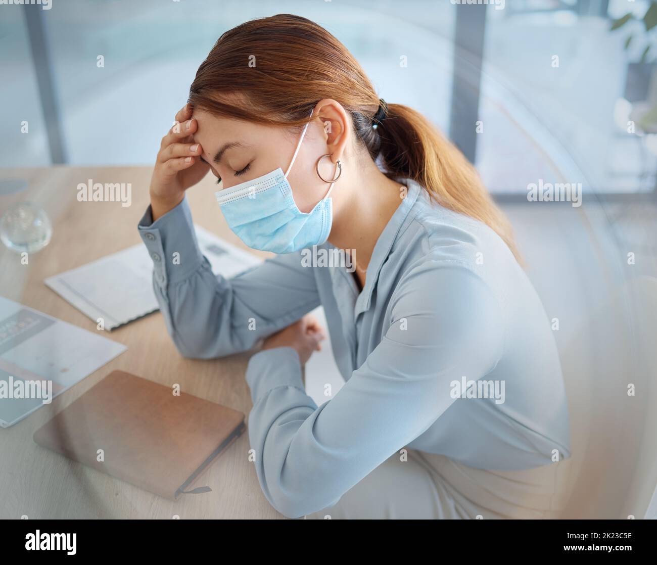 Covid, mal di testa e maschera facciale su donna d'affari in ufficio compliance, startup aziendale e società. Malato, ansia e burnout lavoratore o stanco Foto Stock