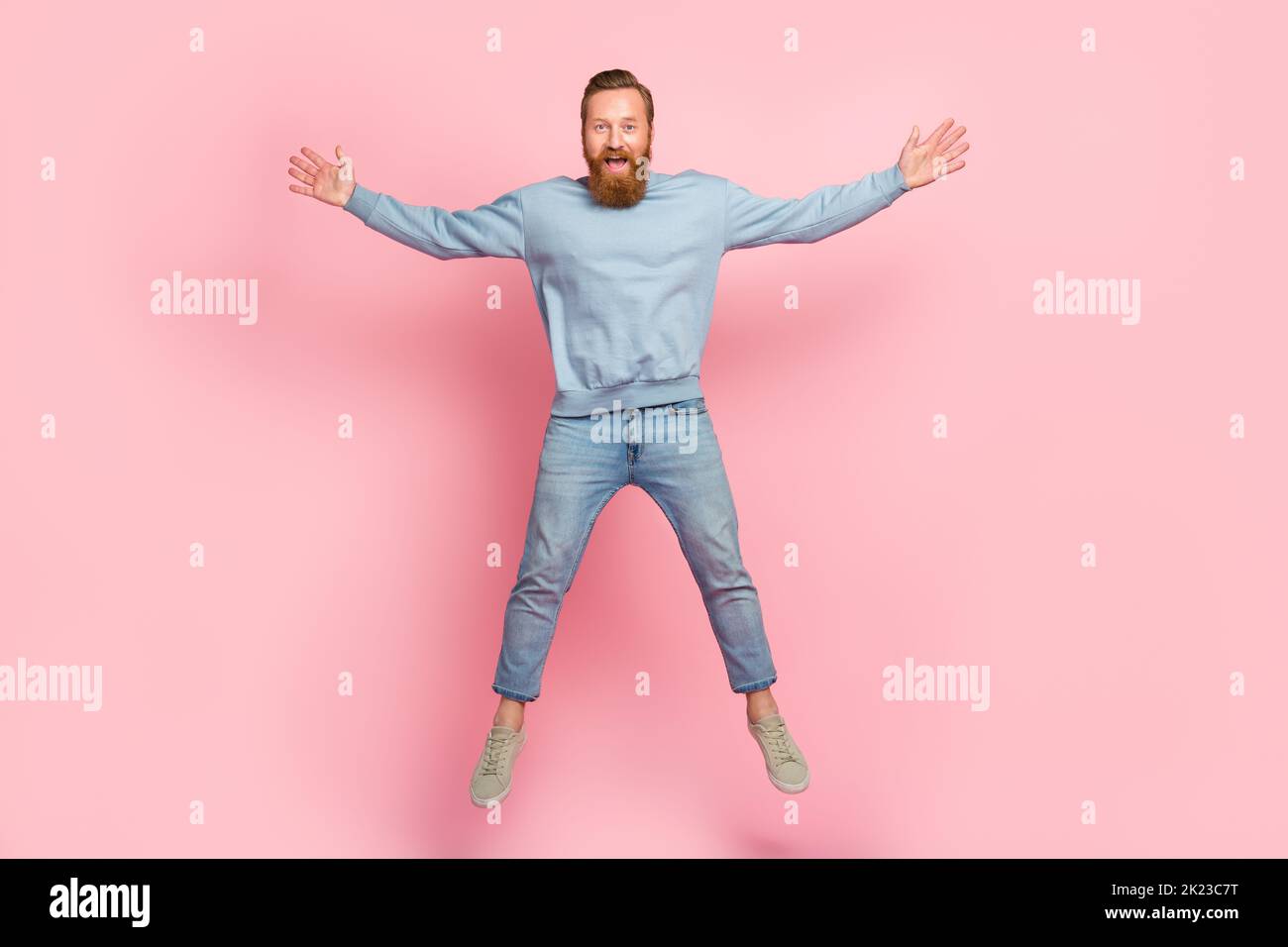 Ritratto completo del corpo di persona soddisfatta overjoyed che salta figura della stella maschile isolata su sfondo di colore rosa Foto Stock
