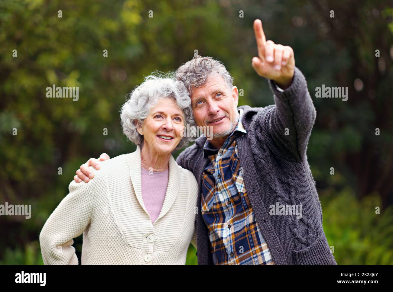 Trascorrere del tempo in giardino. Un uomo anziano che indica qualcosa alla moglie fuori. Foto Stock