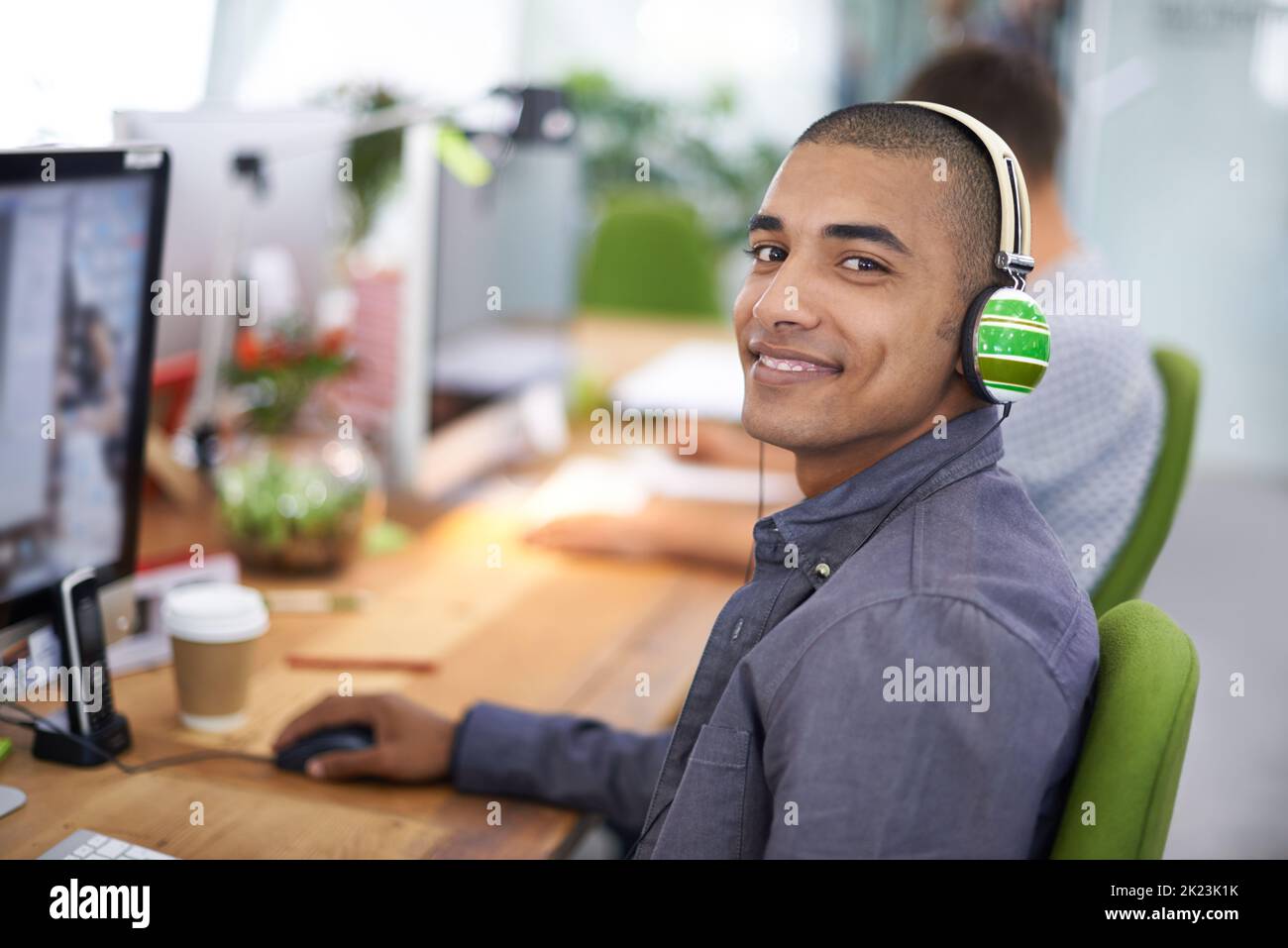 Orgoglioso del suo stile creativo. Vista ritagliata di un giovane designer che lavora al computer con un sorriso. Foto Stock