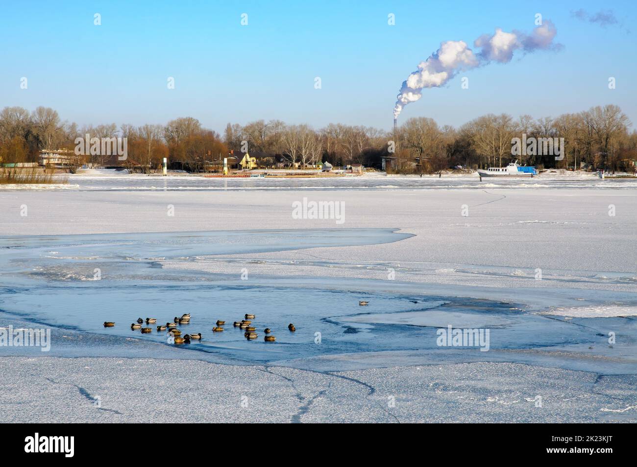 Paesaggio con acqua ghiacciata, ghiaccio e neve sul fiume Dnieper a Kiev, Ucraina, durante l'inverno, anatre riposano sul ghiaccio Foto Stock