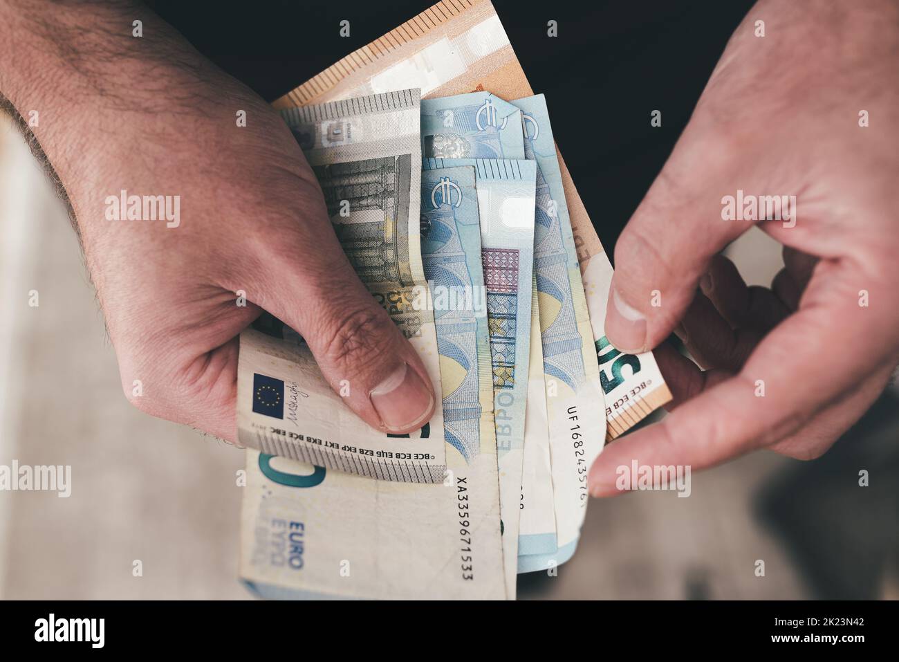vista dall'alto verso il basso delle mani di un uomo in possesso di banconote in euro, contando denaro Foto Stock