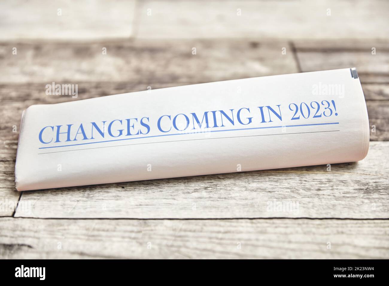 I cambiamenti che arriveranno nel 2023 sono scritti sulla prima pagina di un giornale piegato su un tavolo di legno Foto Stock