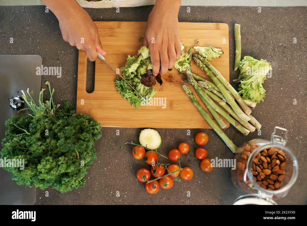 Fresco dalla terra. Una donna che taglia le verdure su un tagliere le tavole. Foto Stock Fresco dalla terra. Una donna che taglia le verdure su un tagliere le tavole. Foto Stock