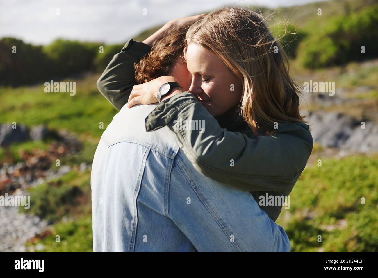 Sicuro nel suo abbraccio caldo. Una giovane coppia affettuosa che passa il tempo insieme all'aperto. Foto Stock