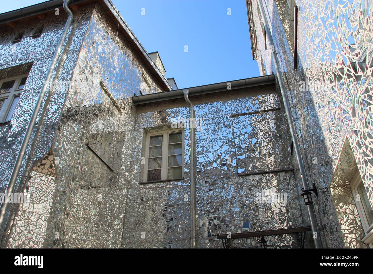 Edificio con pareti a specchio. Facciata di edificio in frammenti di specchio. Pareti di casa coperta da pezzi di specchio. Edificio con pareti in mi Foto Stock