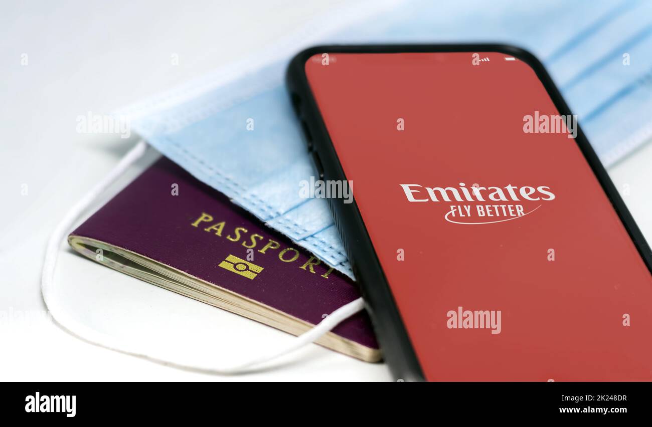 Dubai, Emirati Arabi Uniti, luglio 2021: Telefona con l'app Emirates Airlines sullo schermo sopra una maschera protettiva e un passaporto. Sicurezza durante il viaggio durante il incoronaviru Foto Stock