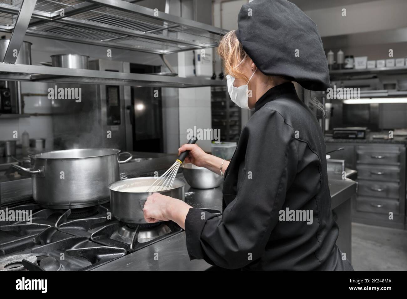 Ritratto di fiducioso chef femminile che lavora in cucina commerciale. Foto di alta qualità Foto Stock
