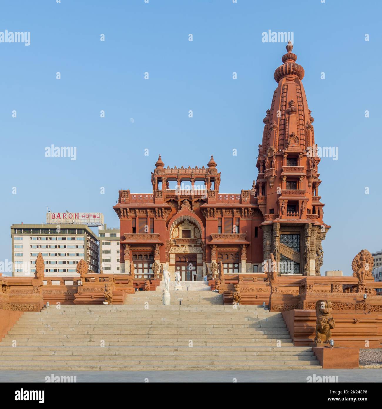 Facciata del Baron Empain Palace, un palazzo storico ispirato al tempio indù cambogiano di Angkor Wat, con il Baron Hotel in fondo, situato in lui Foto Stock