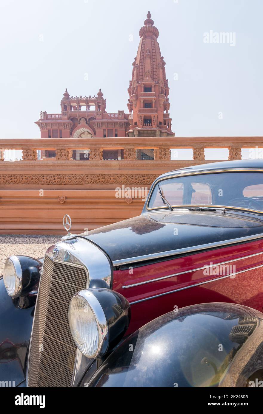 Cairo, Egitto - 29 2020 luglio: 1953 auto d'epoca Mercedes nera e rossa, con il Palazzo Barone Empain all'estremità lontana, quartiere Heliopolis Foto Stock