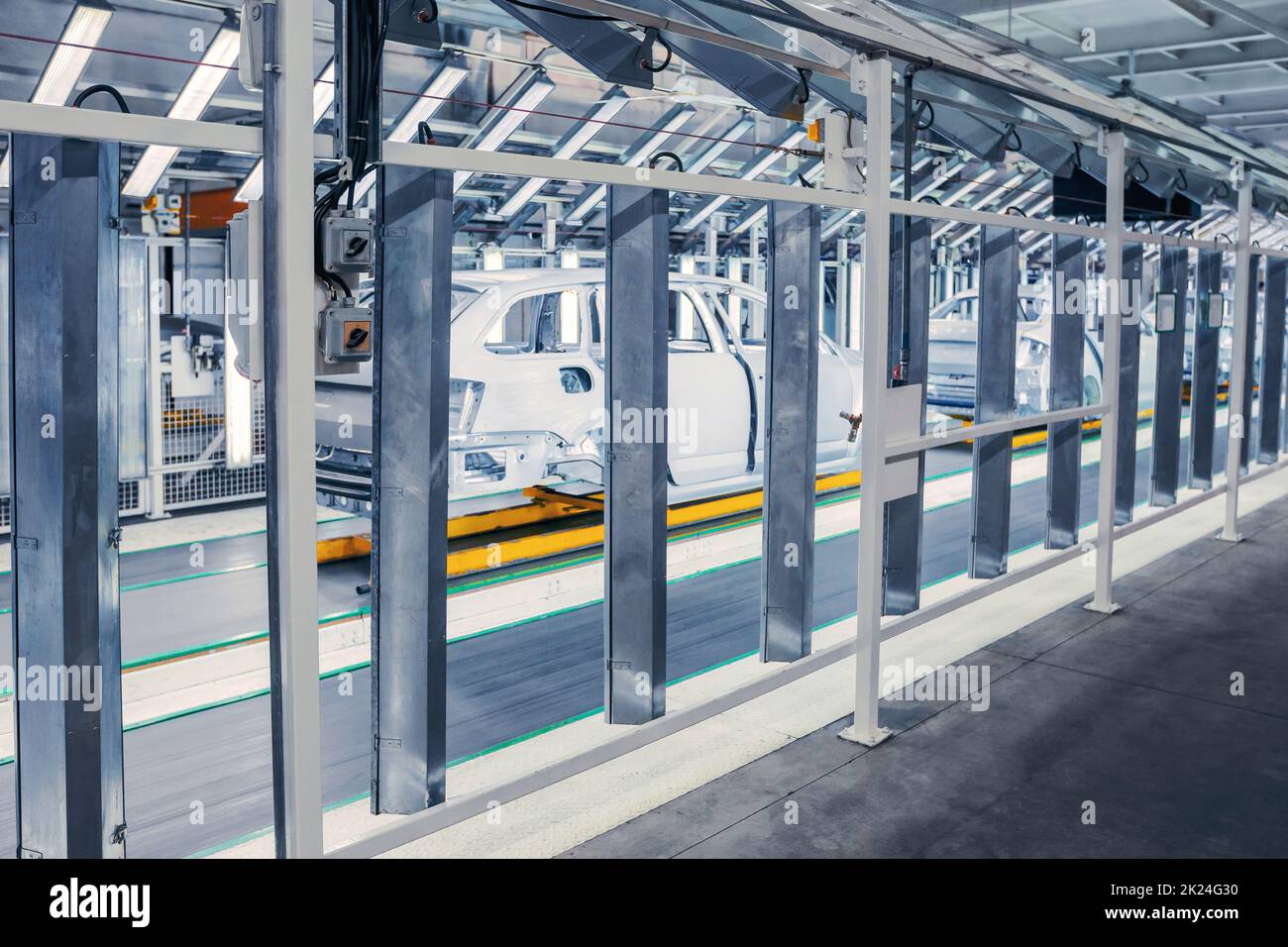 vetture preparate in fila nel tunnel di controllo presso lo stabilimento automobilistico Foto Stock