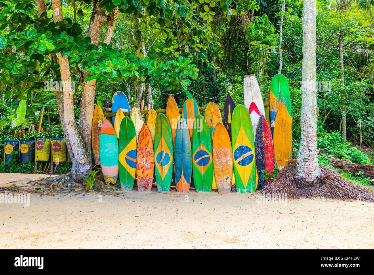 Tavole da surf colorate con bandiera brasiliana presso la splendida spiaggia di Mangrove e Pooso sulla grande isola tropicale Ilha Grande Rio de Janeiro Brasile. Foto Stock